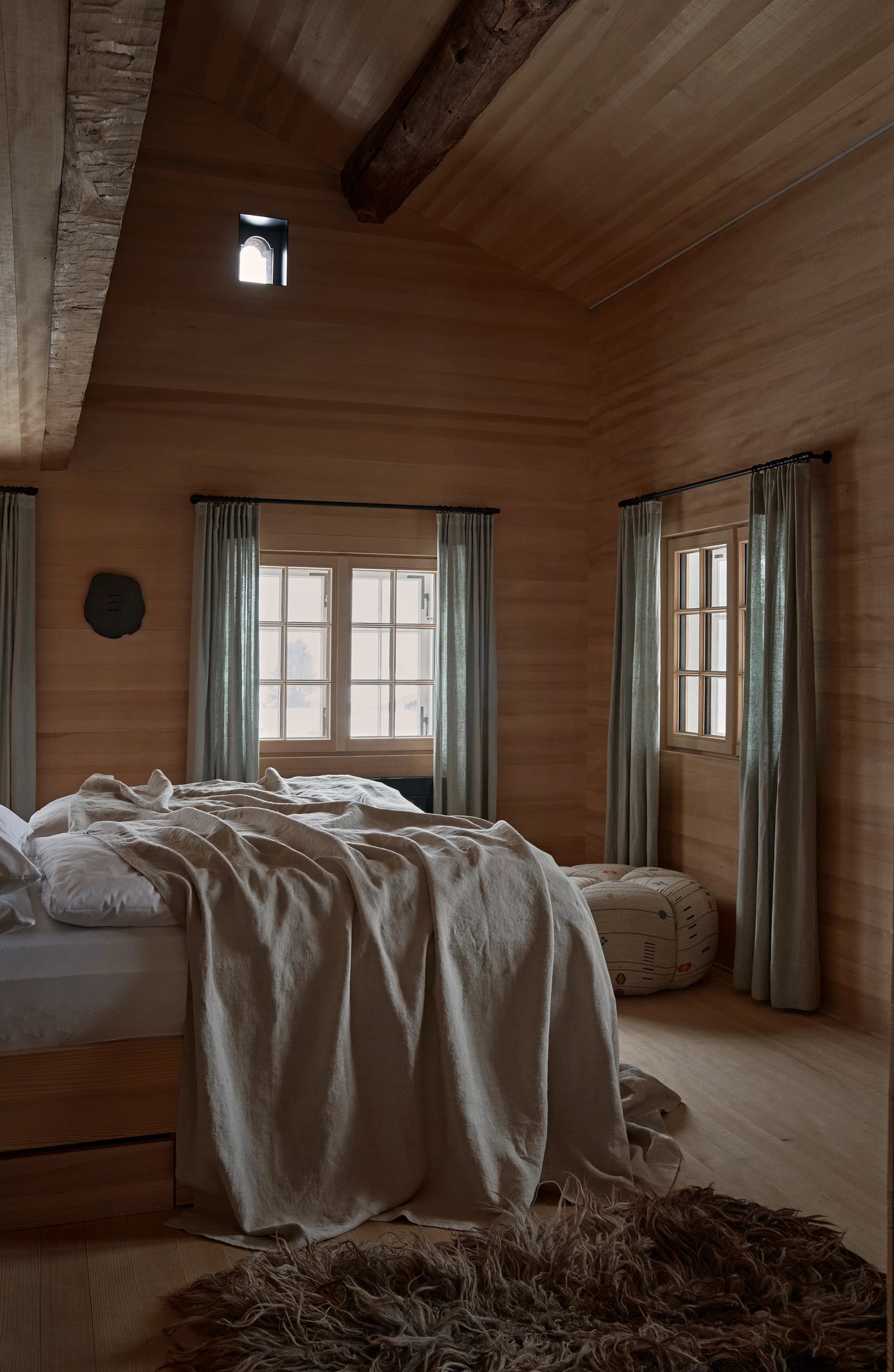 Bedroom with aged timber wall and wall lamps
